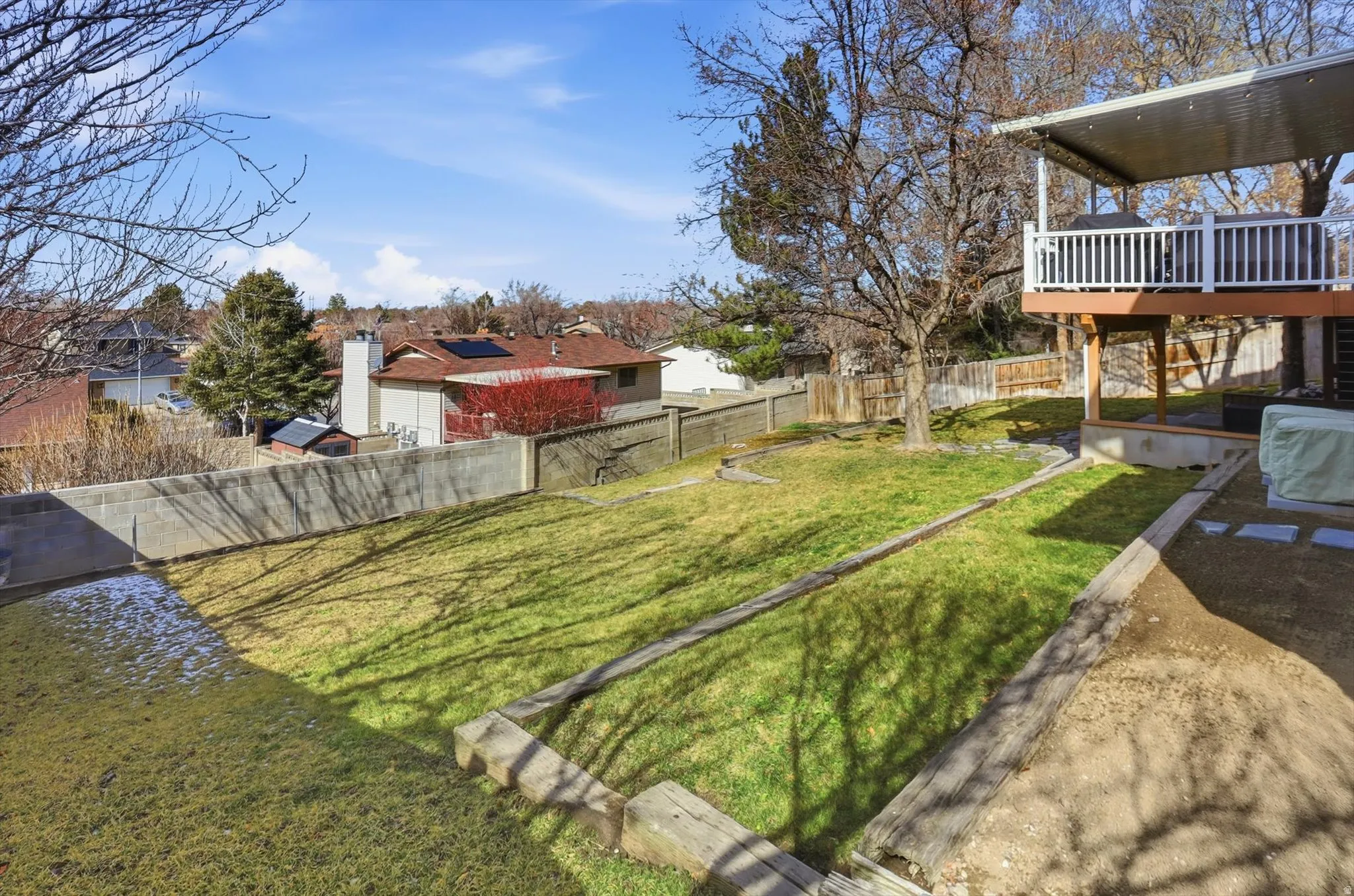Fenced backyard featuring a deck and a residential view