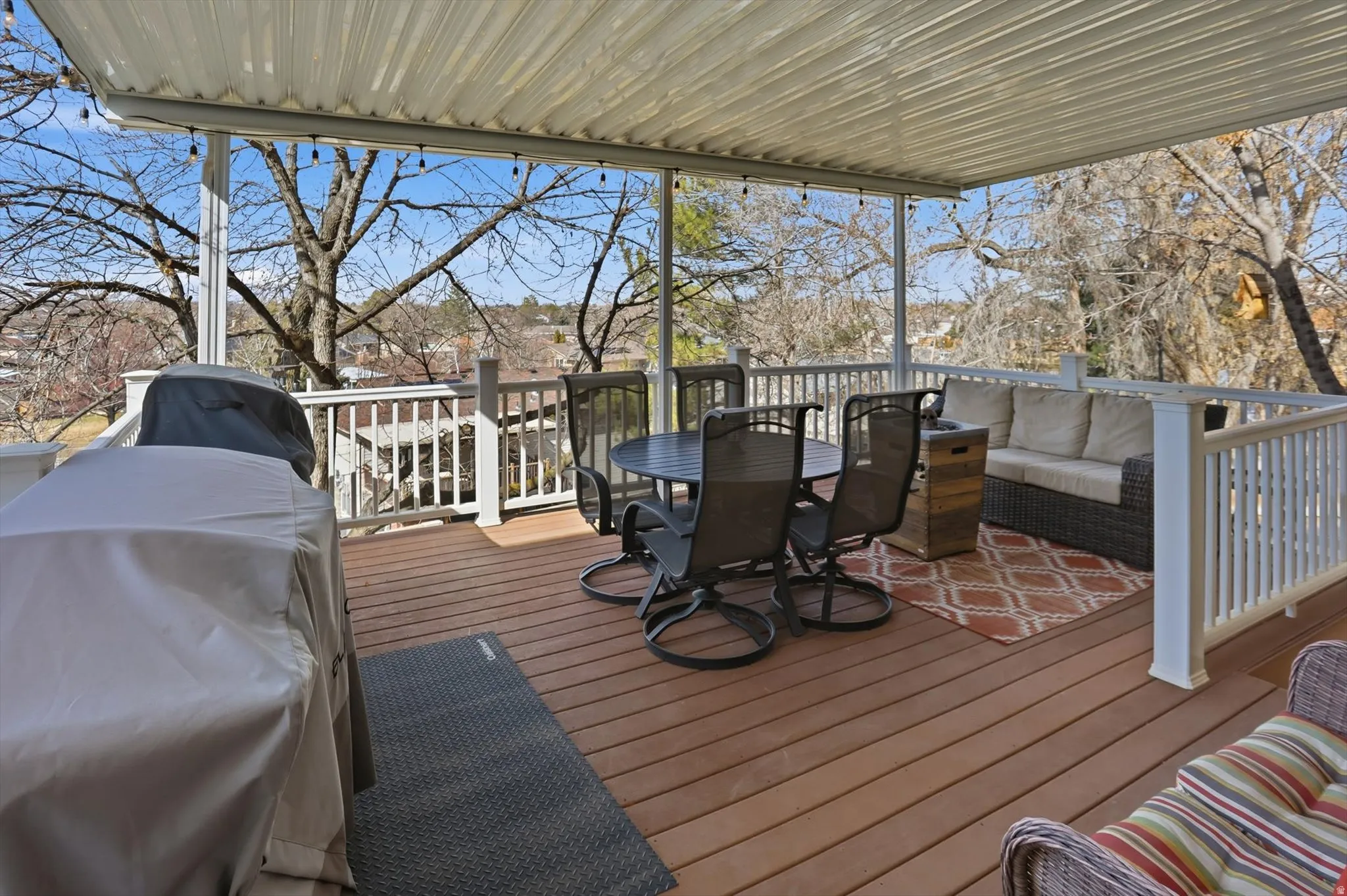 Wooden deck with outdoor lounge area and a grill