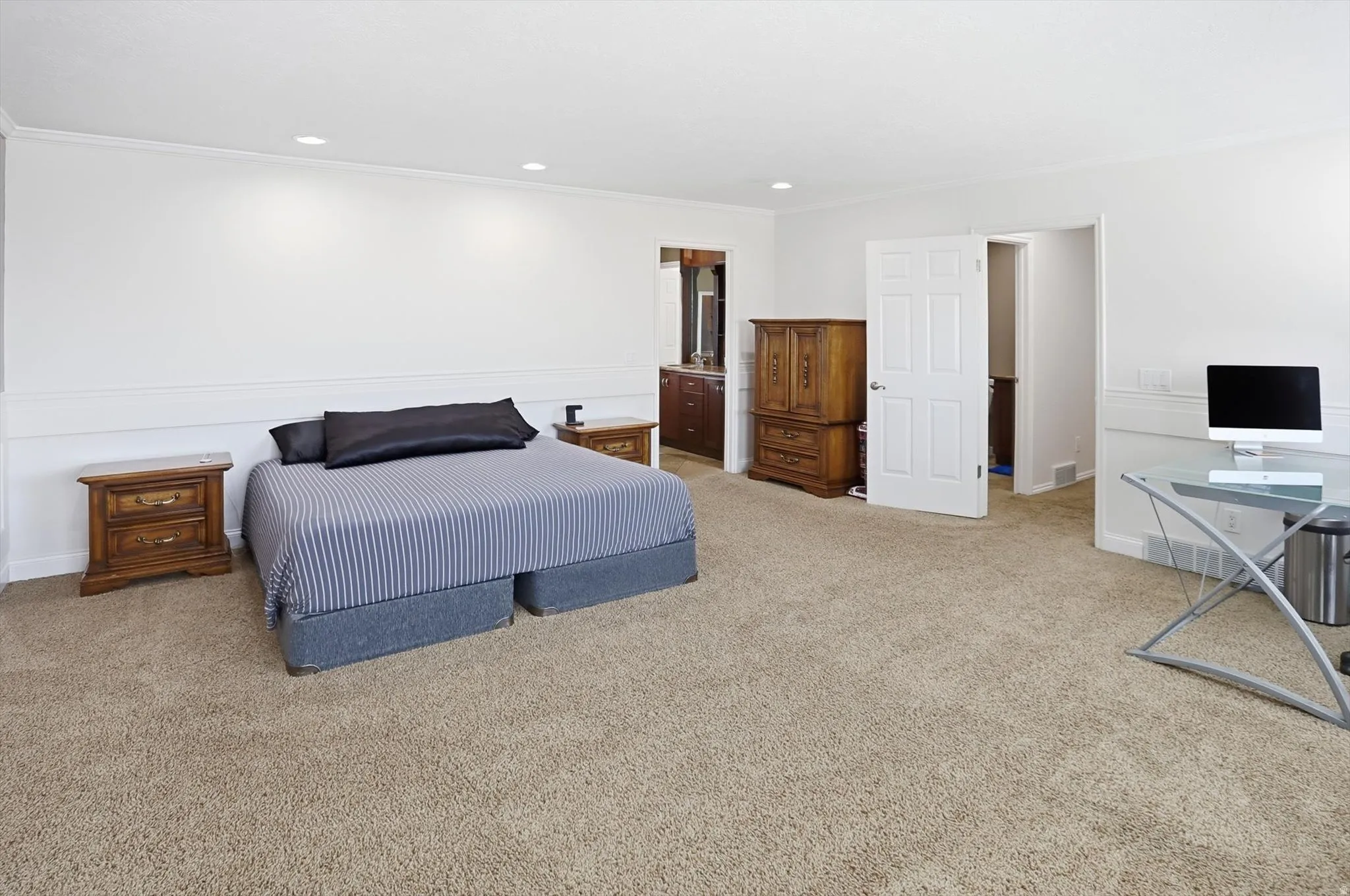 Carpeted bedroom with ornamental molding, recessed lighting, an office area, and connected bathroom