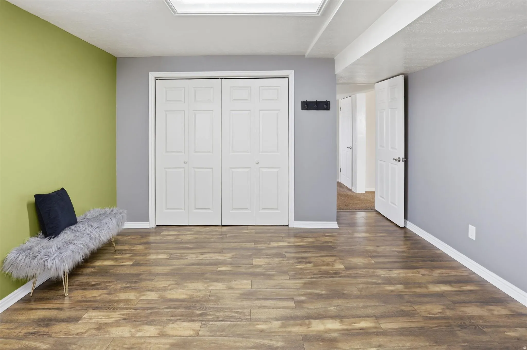 Bedroom with dark wood finished floors and a closet