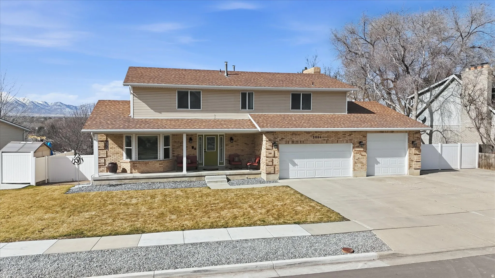 Traditional home with a porch, a chimney, concrete driveway, and brick siding