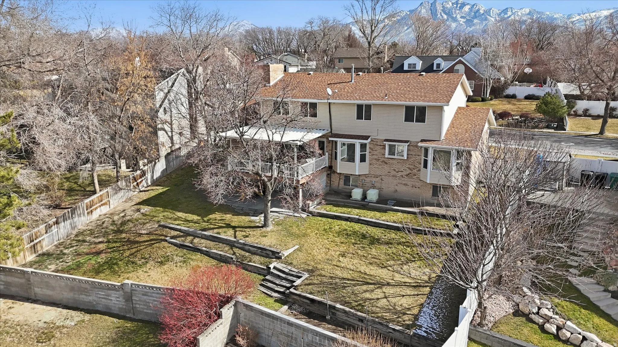 Rear view of property with a fenced backyard, a balcony, and a chimney