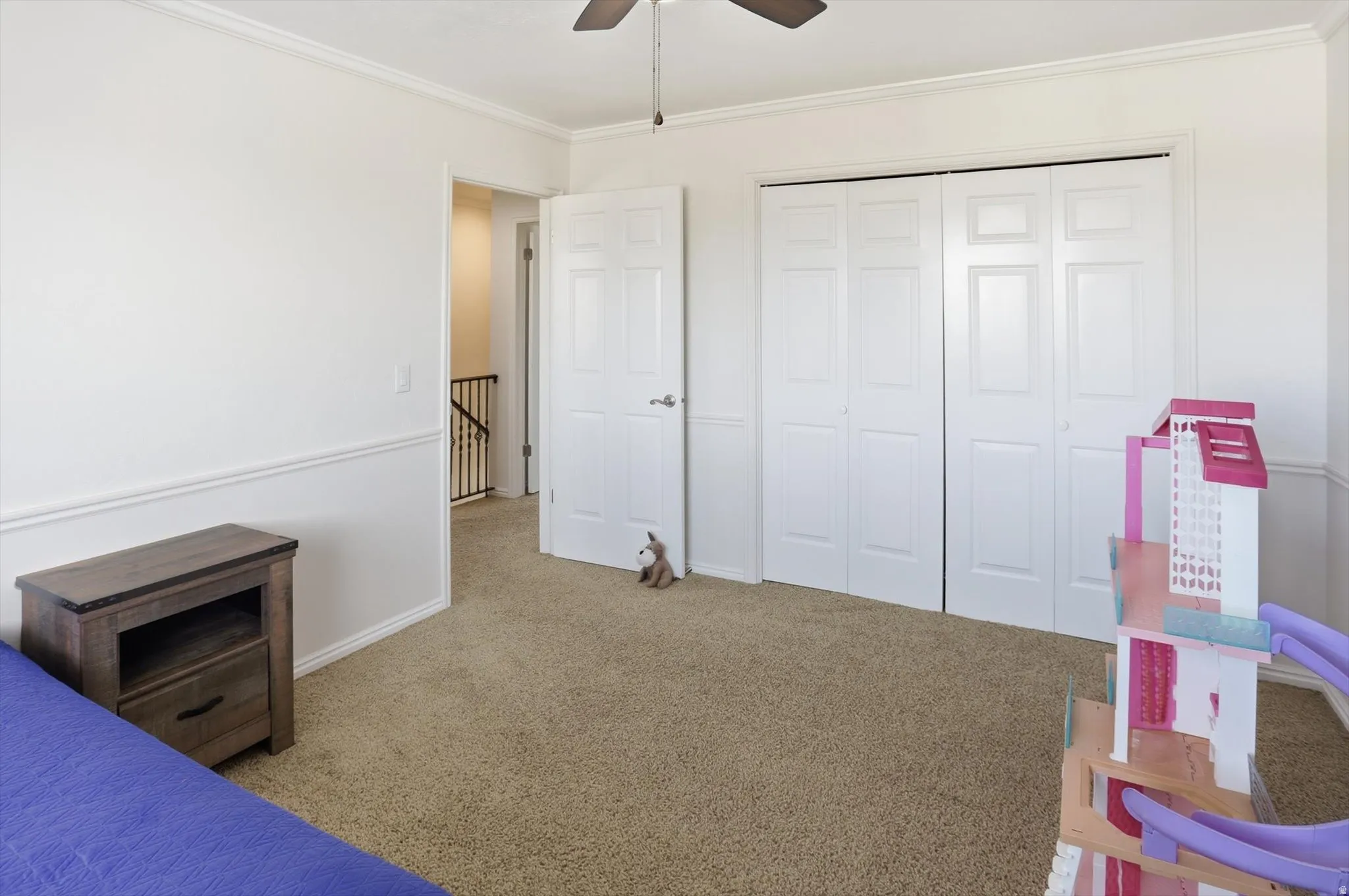 Unfurnished bedroom with carpet flooring, crown molding, ceiling fan, and a closet