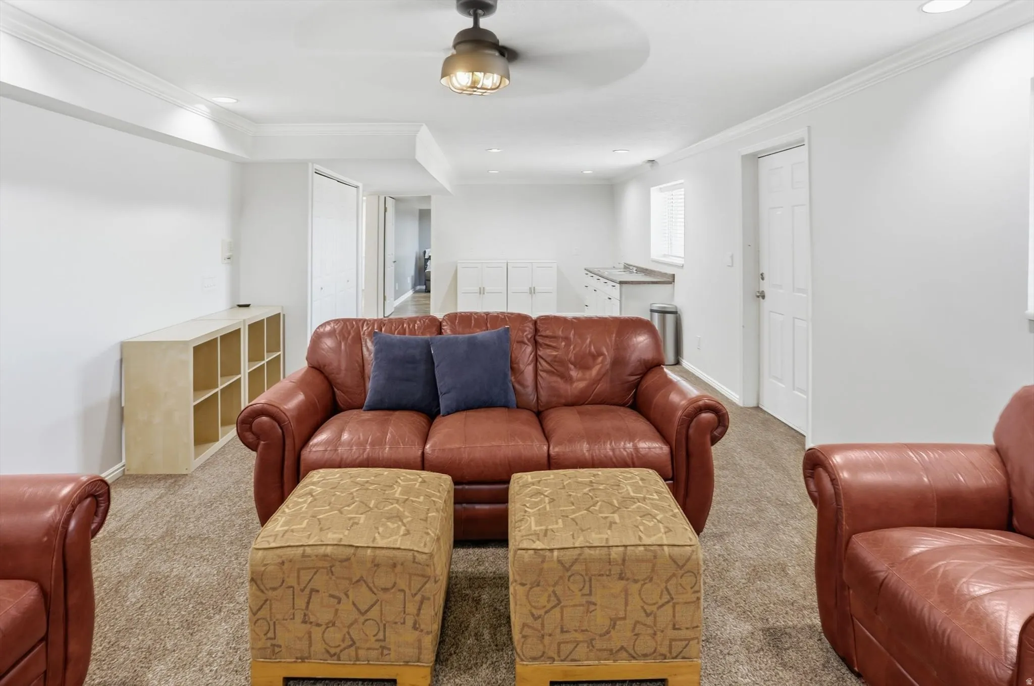 Living area with carpet, ceiling fan, crown molding, and recessed lighting