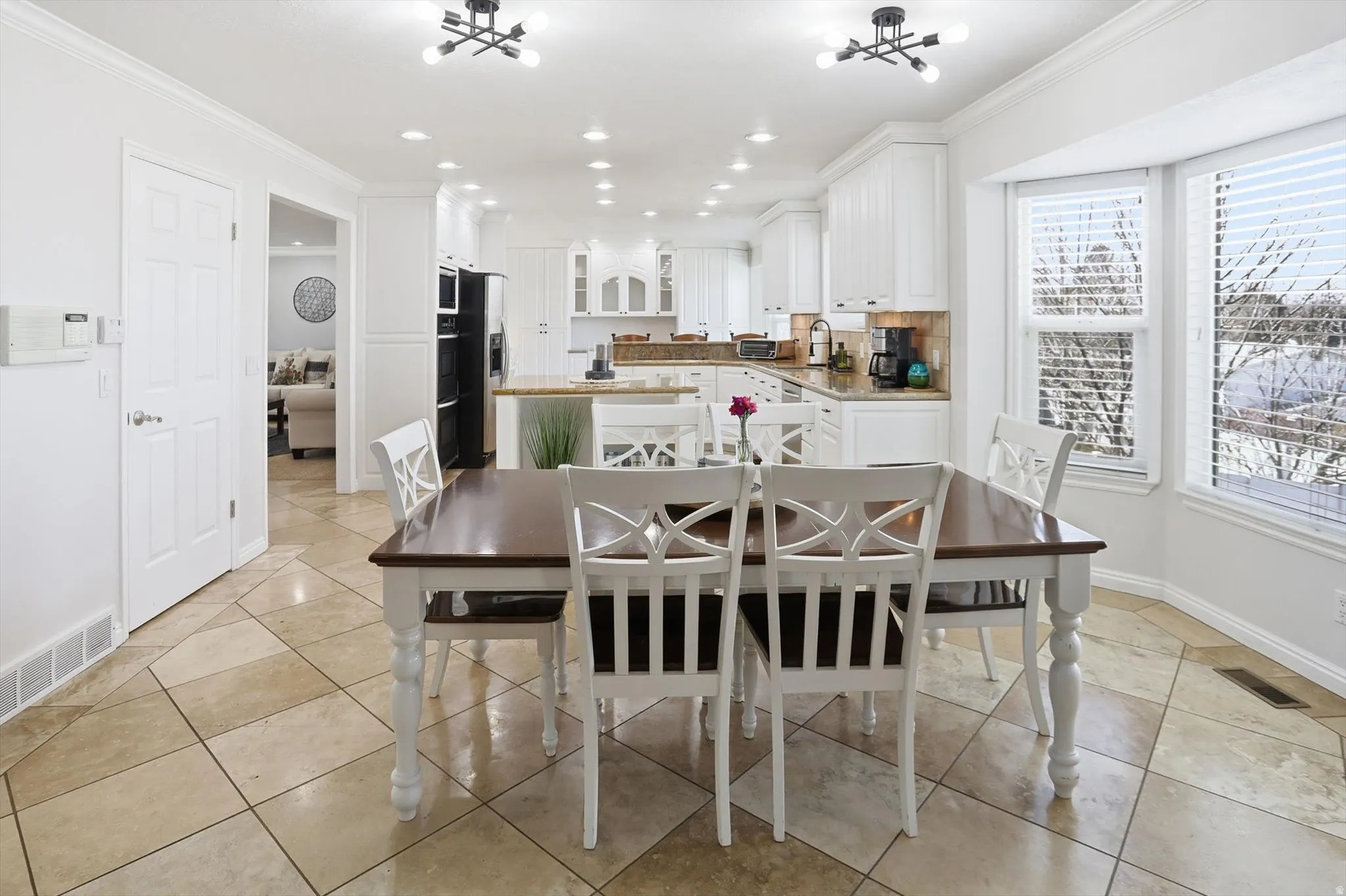 Dining space with ornamental molding, light tile patterned floors, and recessed lighting