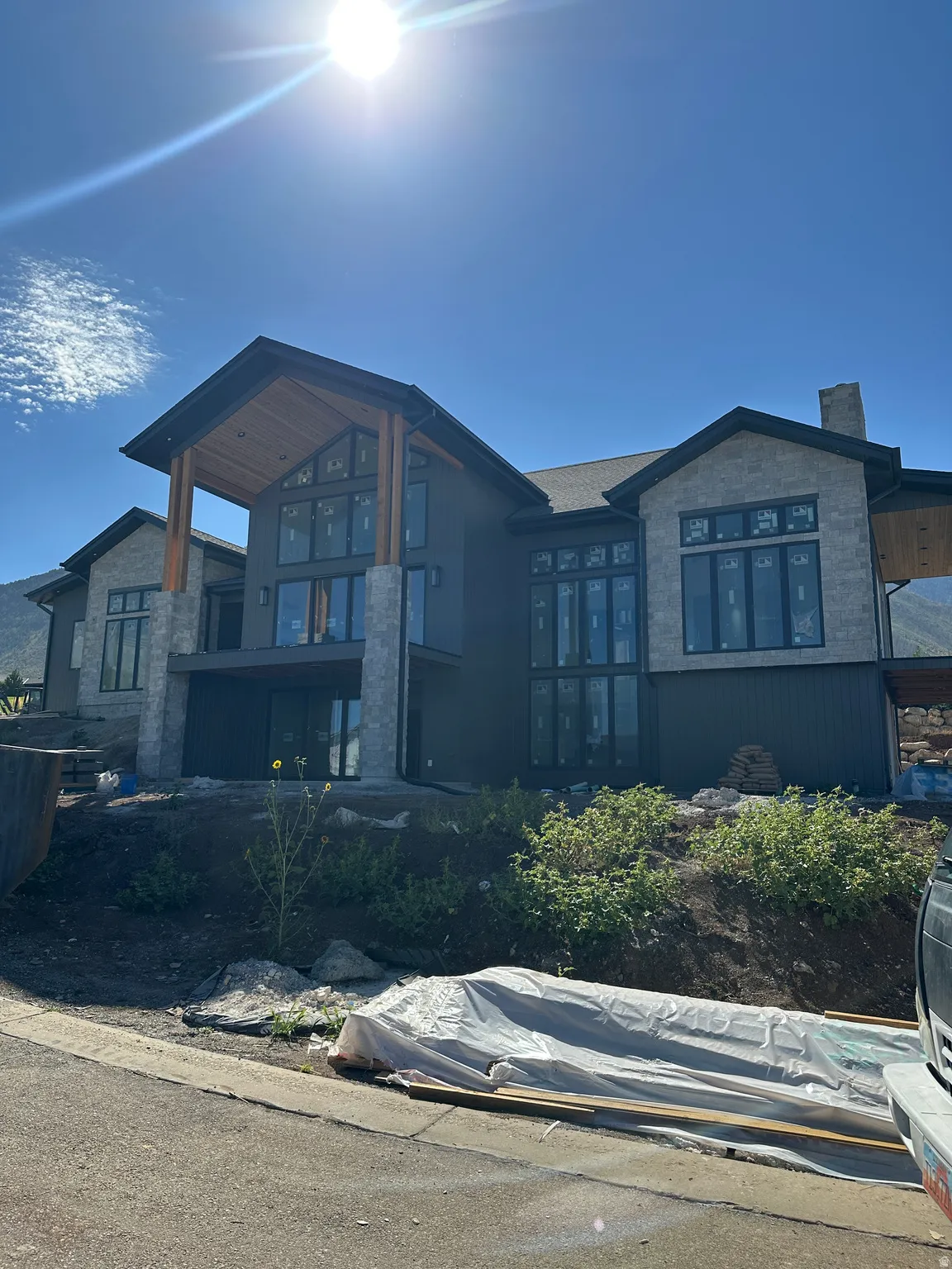 Stone and dark-toned siding exterior with expansive window arrangements