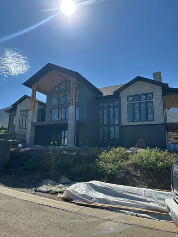 Stone and dark-toned siding exterior with expansive window arrangements