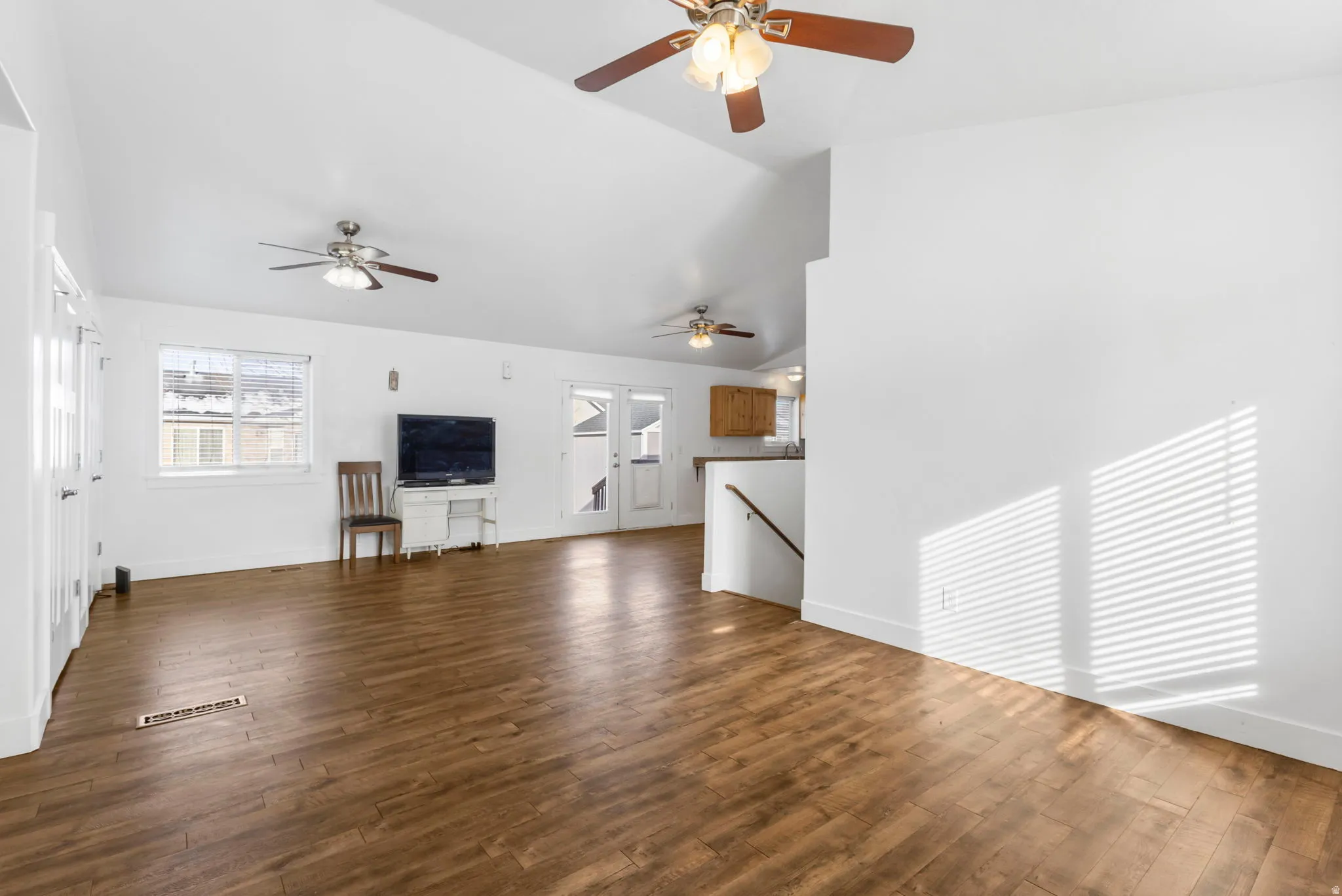 Unfurnished living room featuring dark wood-style floors and vaulted ceiling