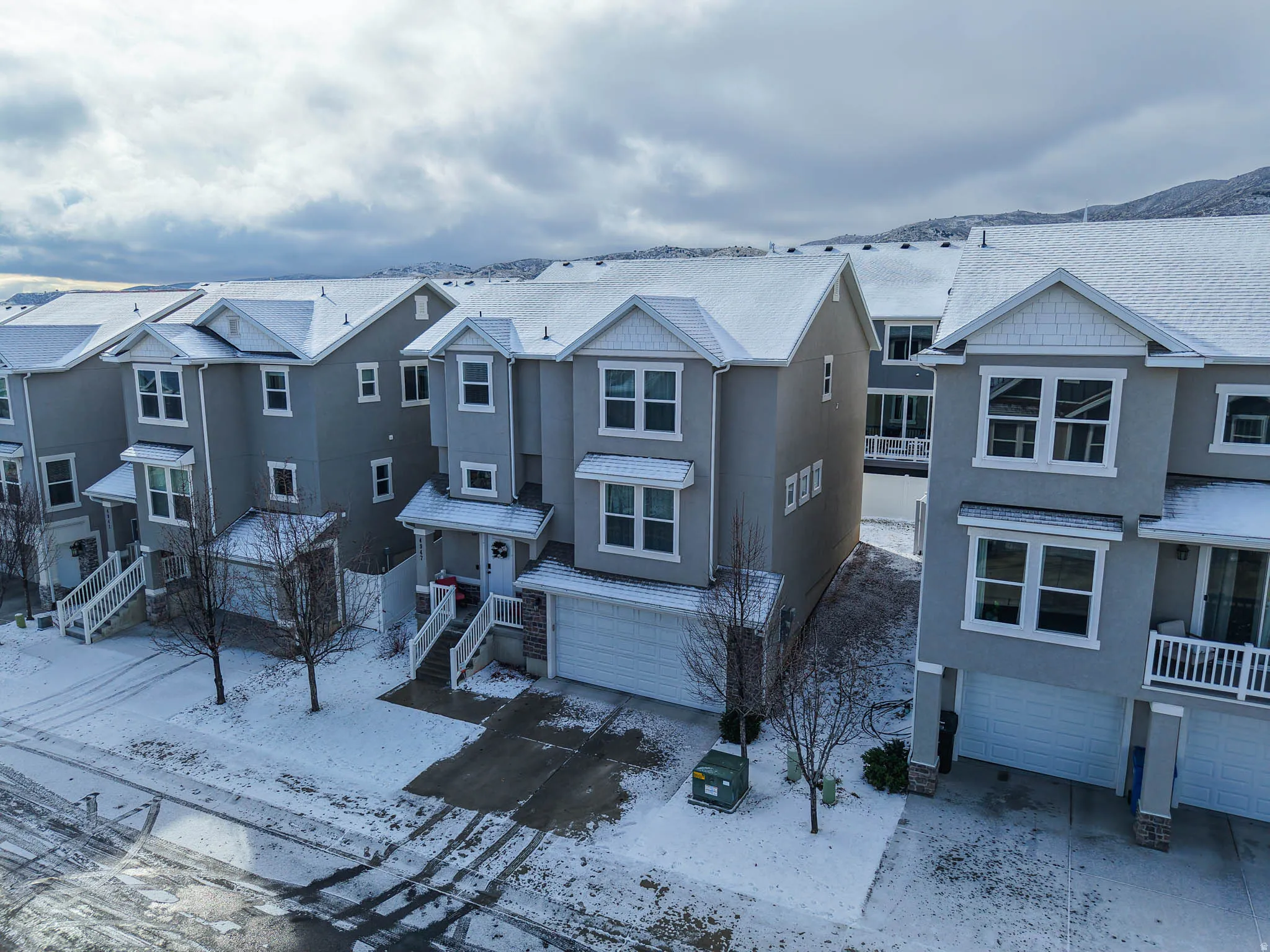 View of front of home featuring a garage, stucco siding, a residential view, and driveway