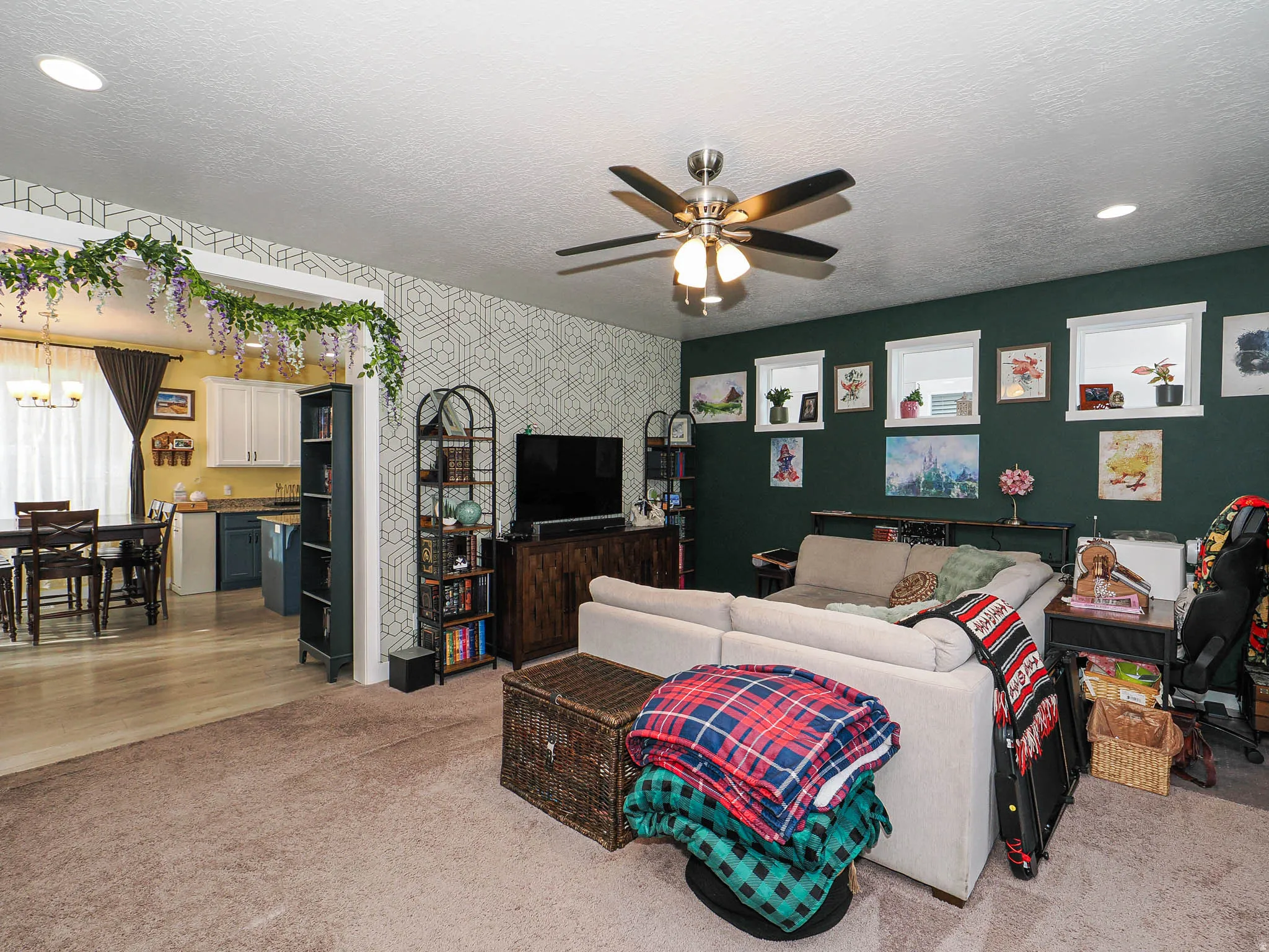 Living room with light colored carpet, a textured ceiling, ceiling fan, and hanging lights