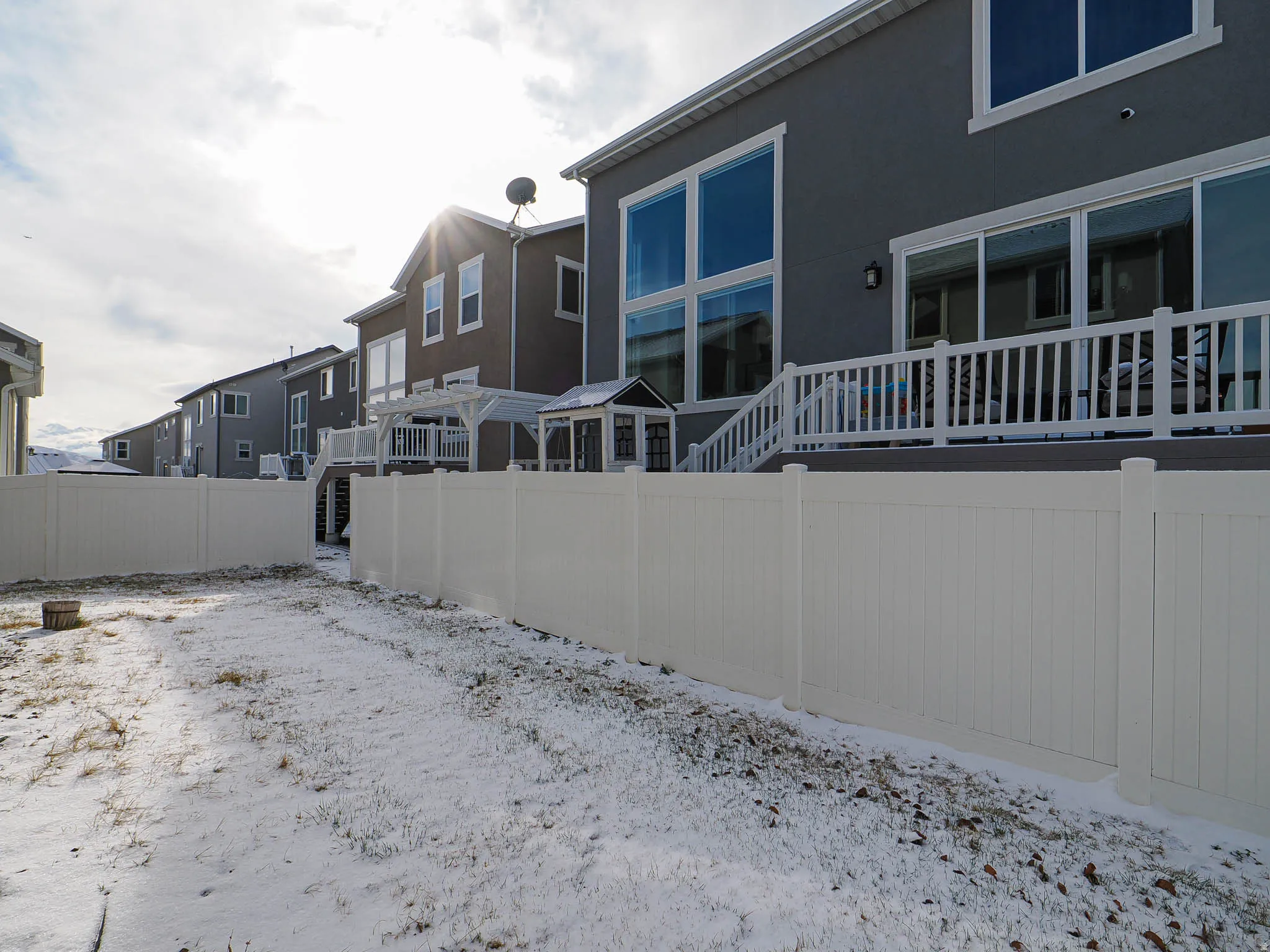 Snow covered property with stucco siding and a residential view