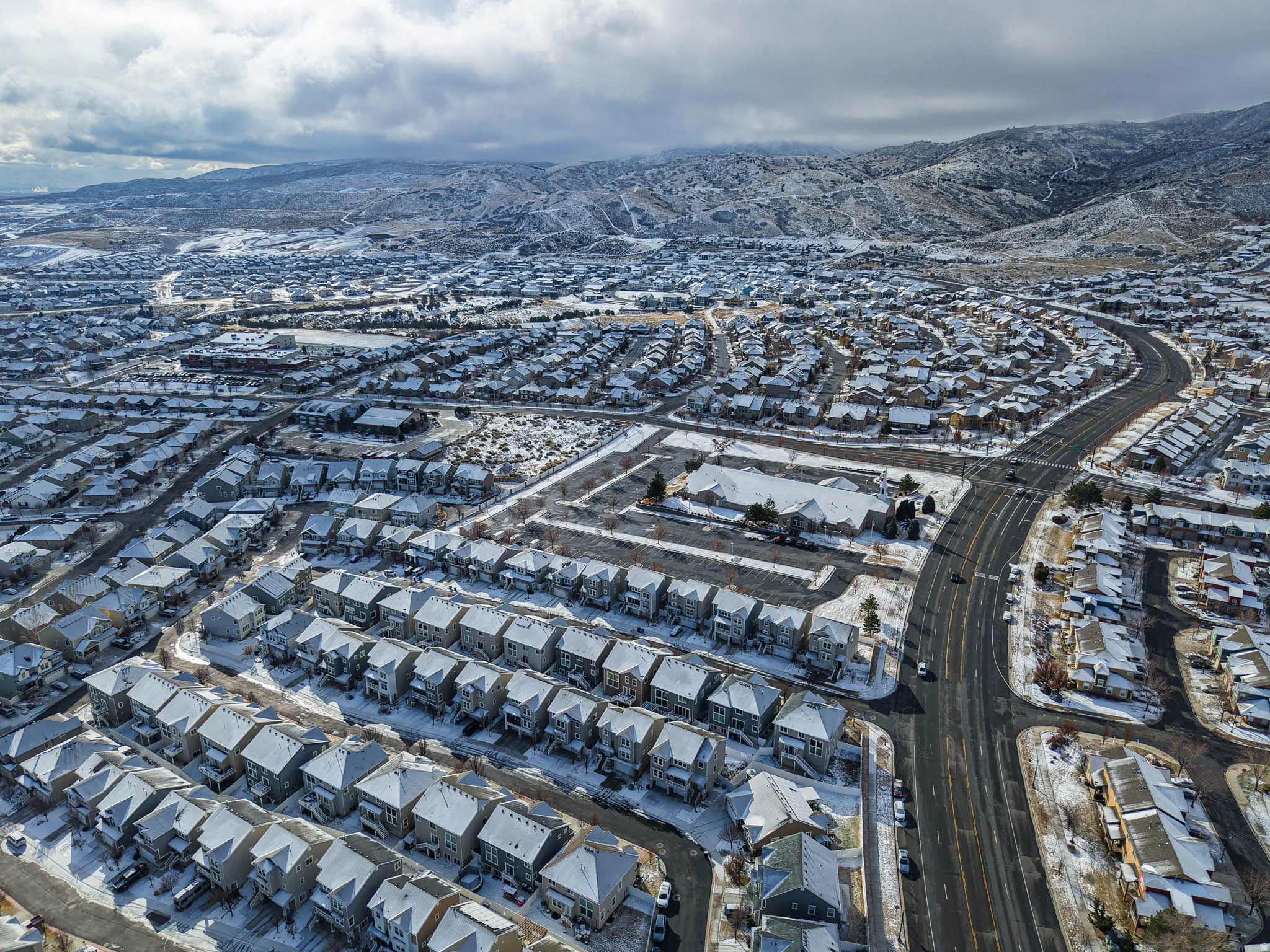 Snowy aerial view with a mountain view and a residential view