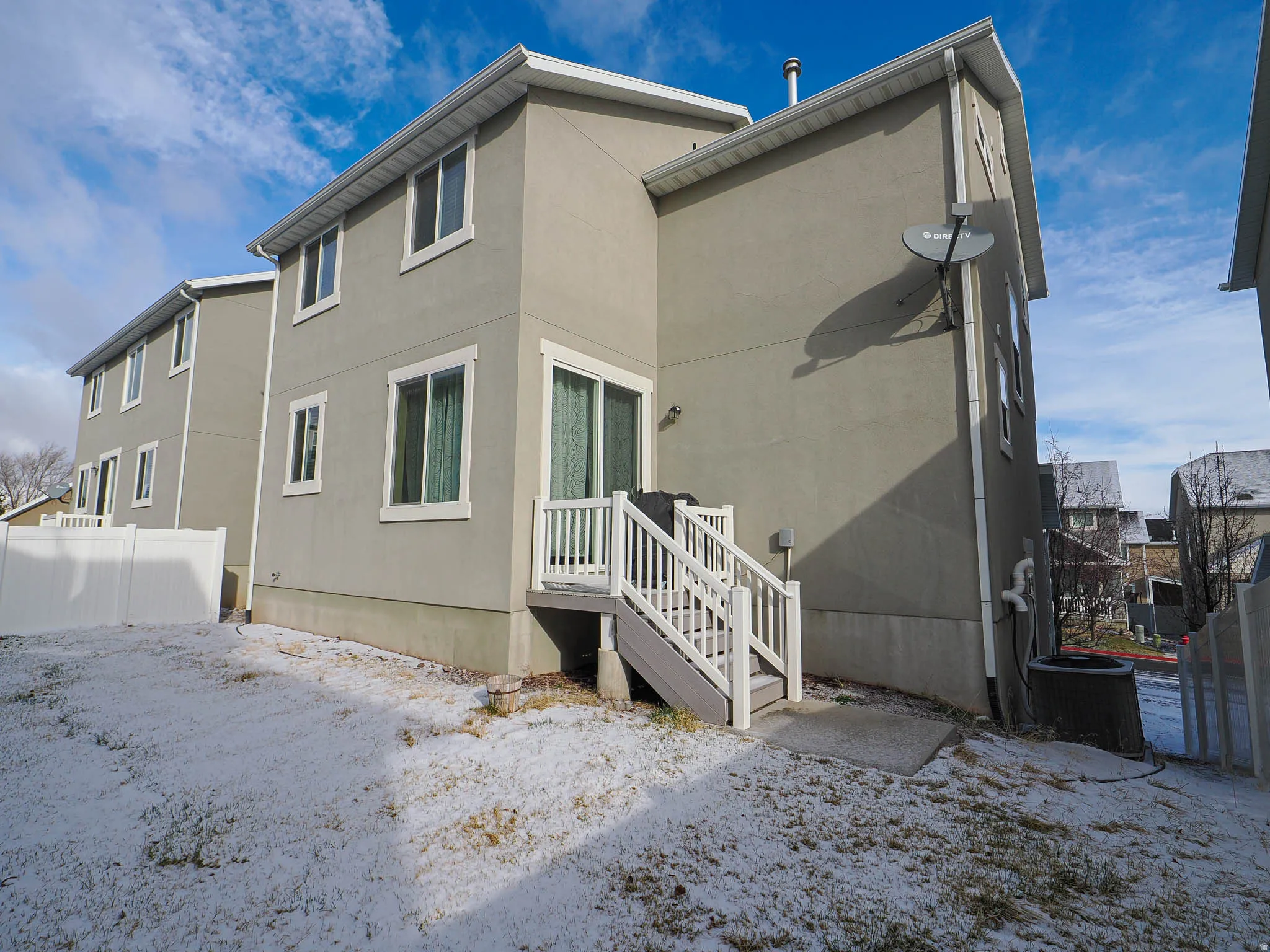 Snow covered house featuring stucco siding