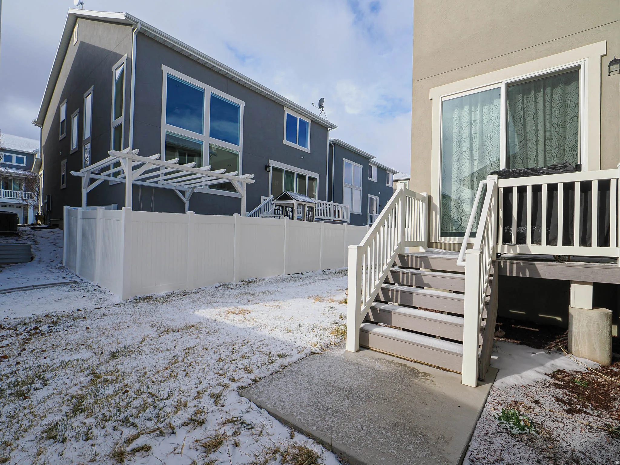View of snowy exterior featuring stucco siding and a patio area