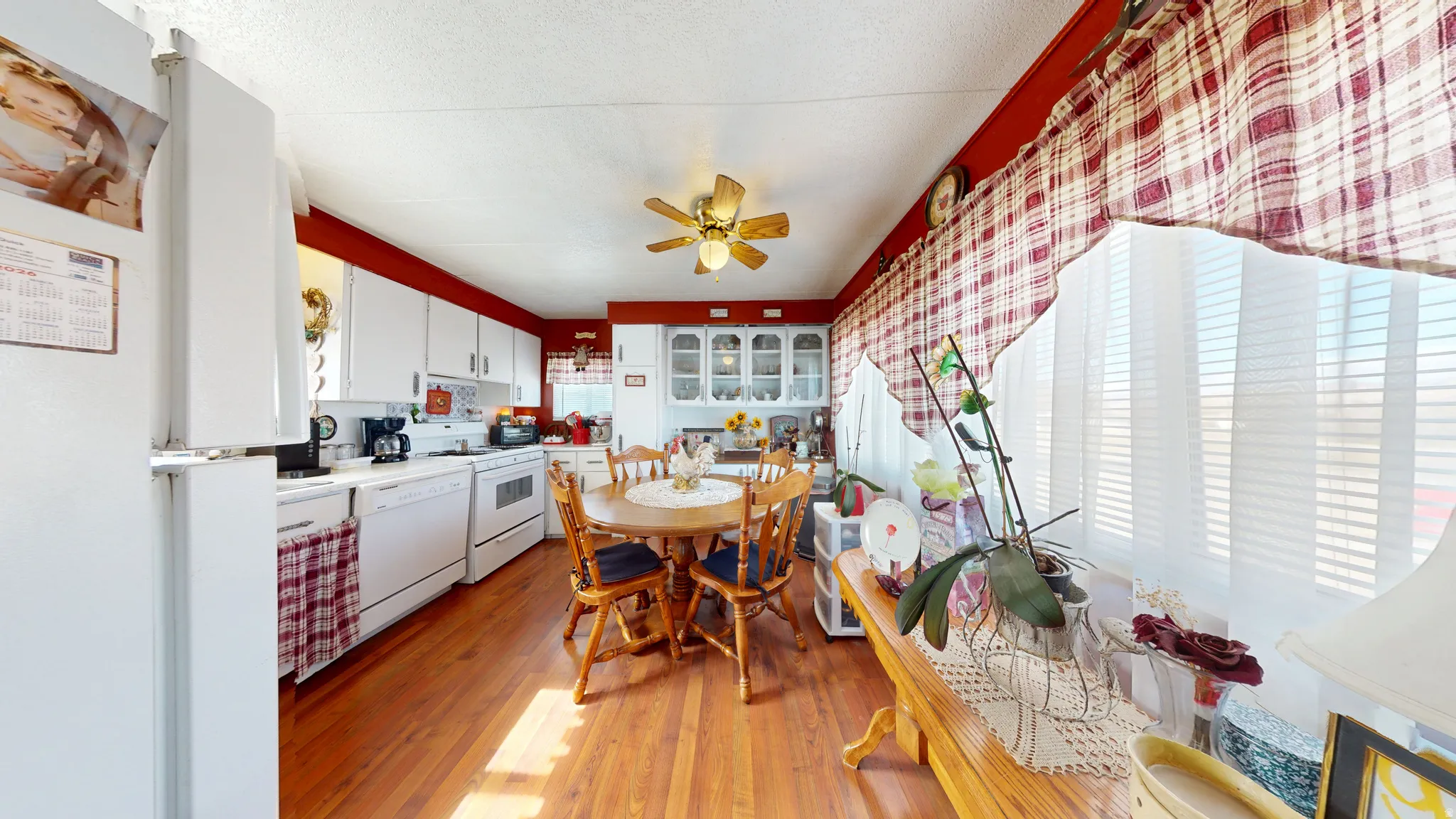 Kitchen with white appliances, white cabinetry, a ceiling fan, light countertops, and light wood finished floors