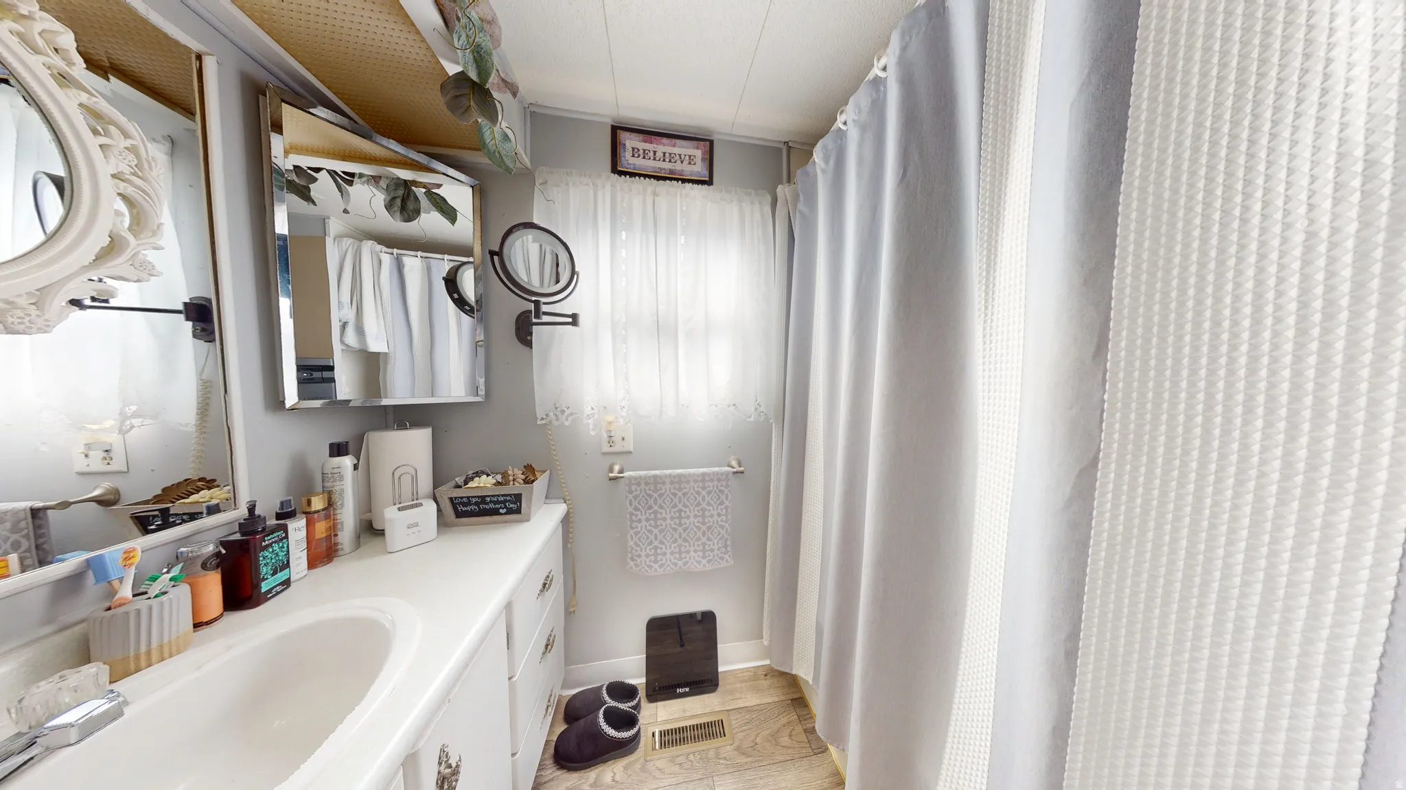 Full bath with vanity, a shower with shower curtain, and light wood finished floors