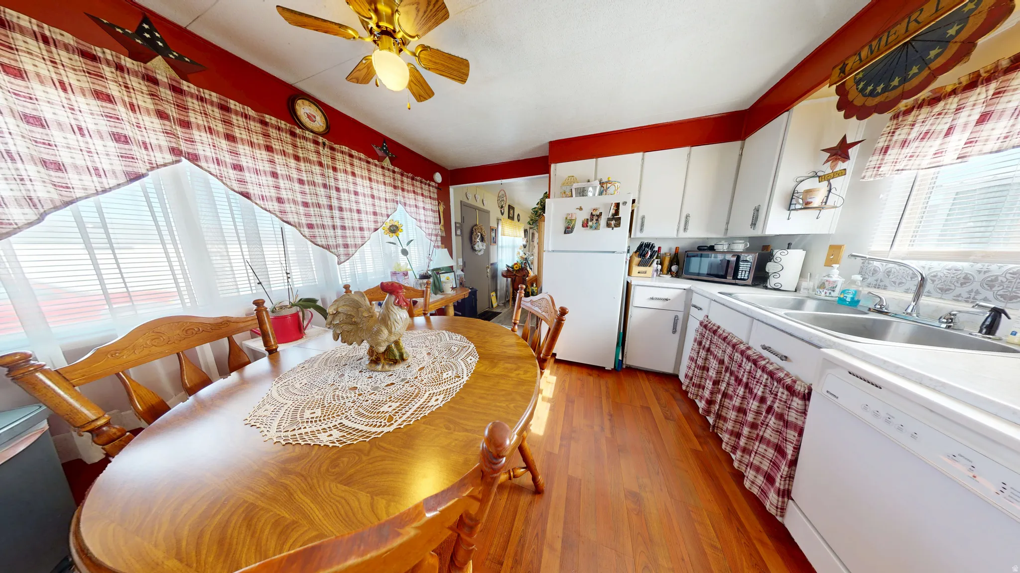 Kitchen featuring white cabinetry, white appliances, and light countertops