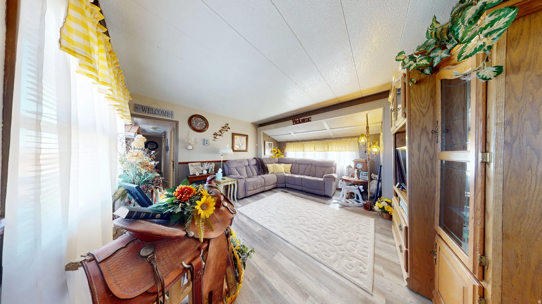 Living area with light wood-type flooring and a textured ceiling