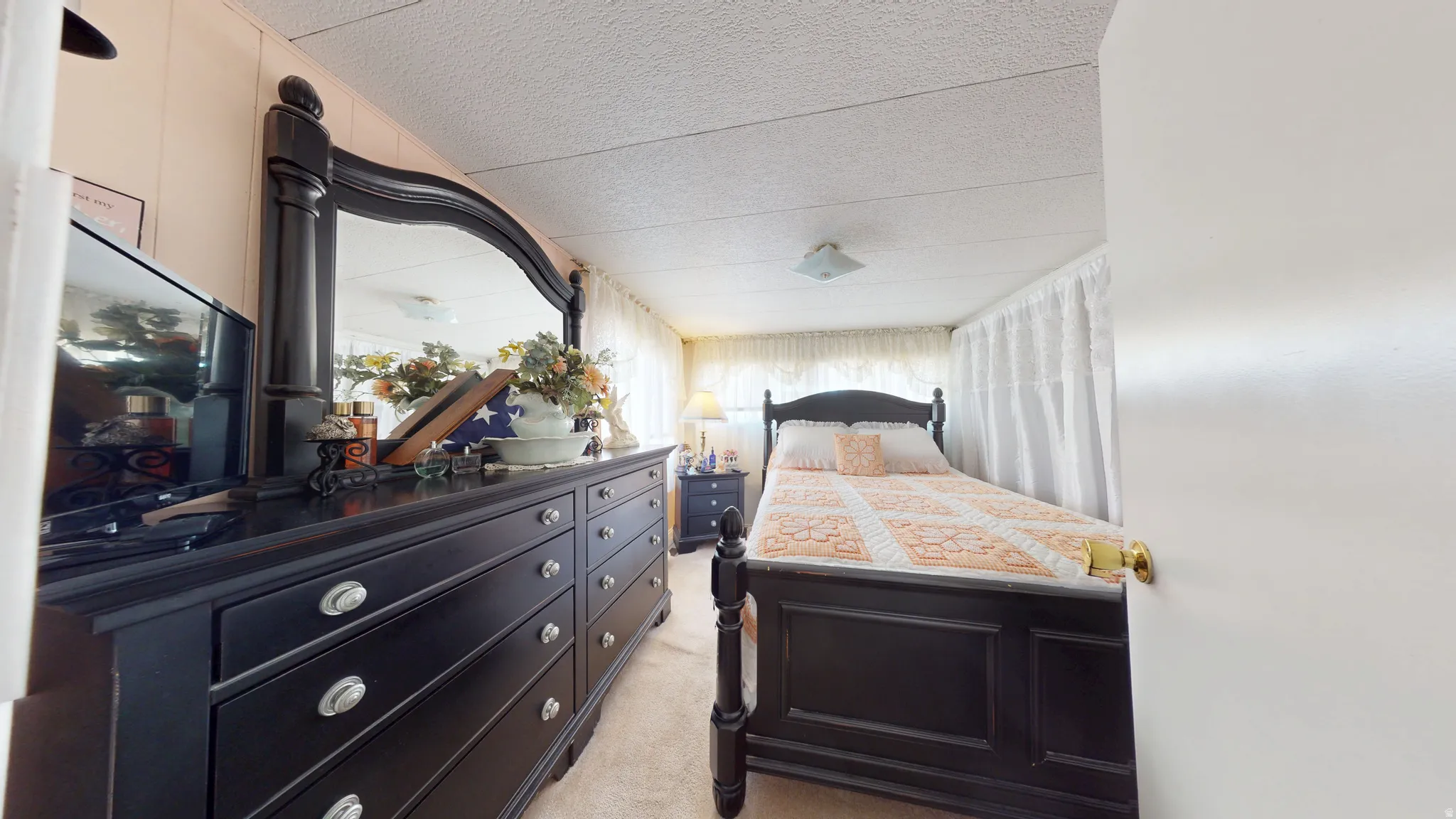 Bedroom with a textured ceiling and light colored carpet