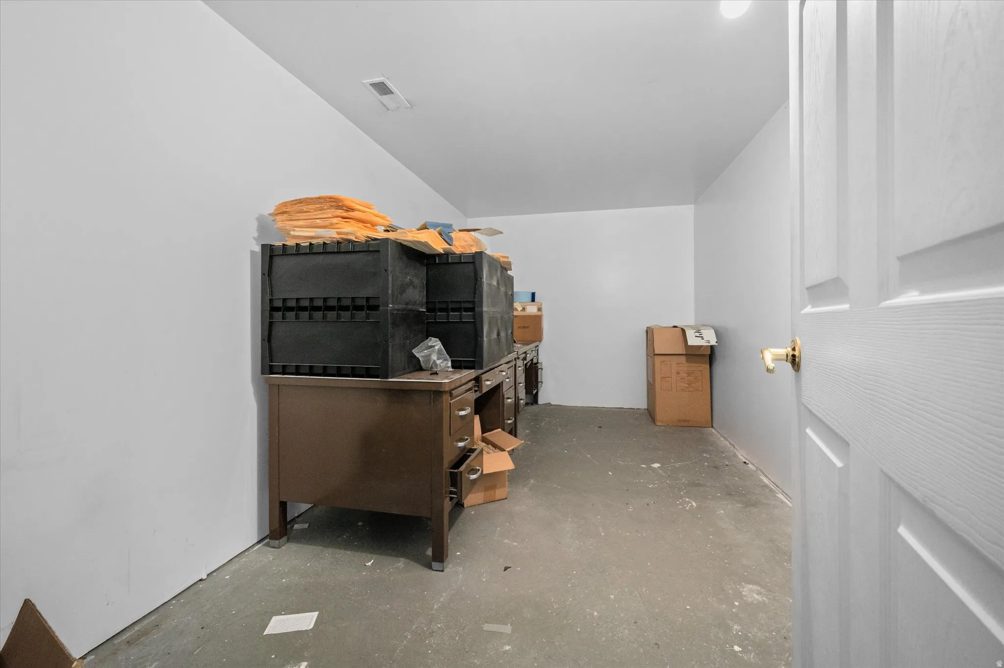 Storage or conference room space with unfinished concrete flooring