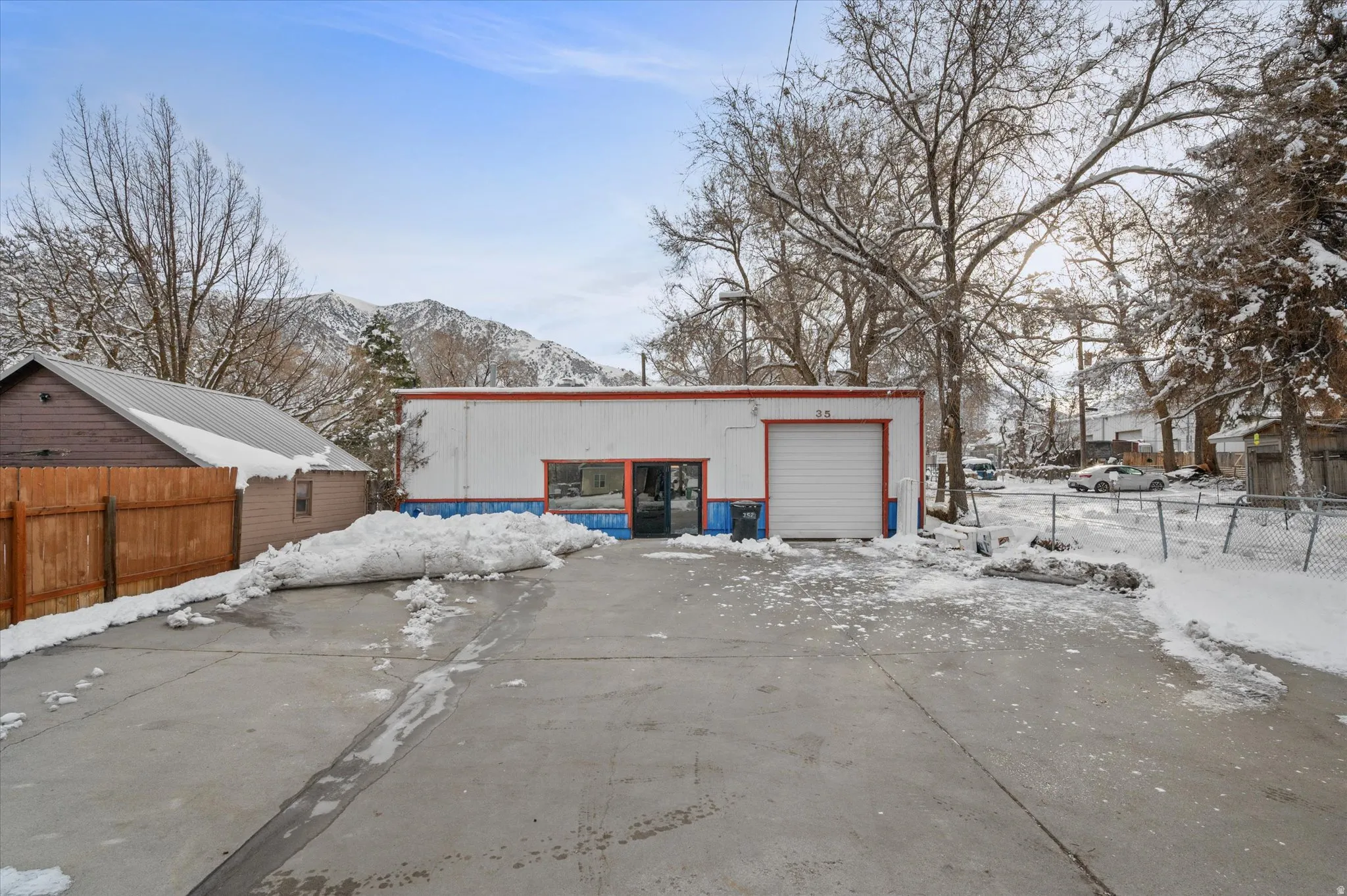 Front of building with large parking lot, front entrance, and garage.