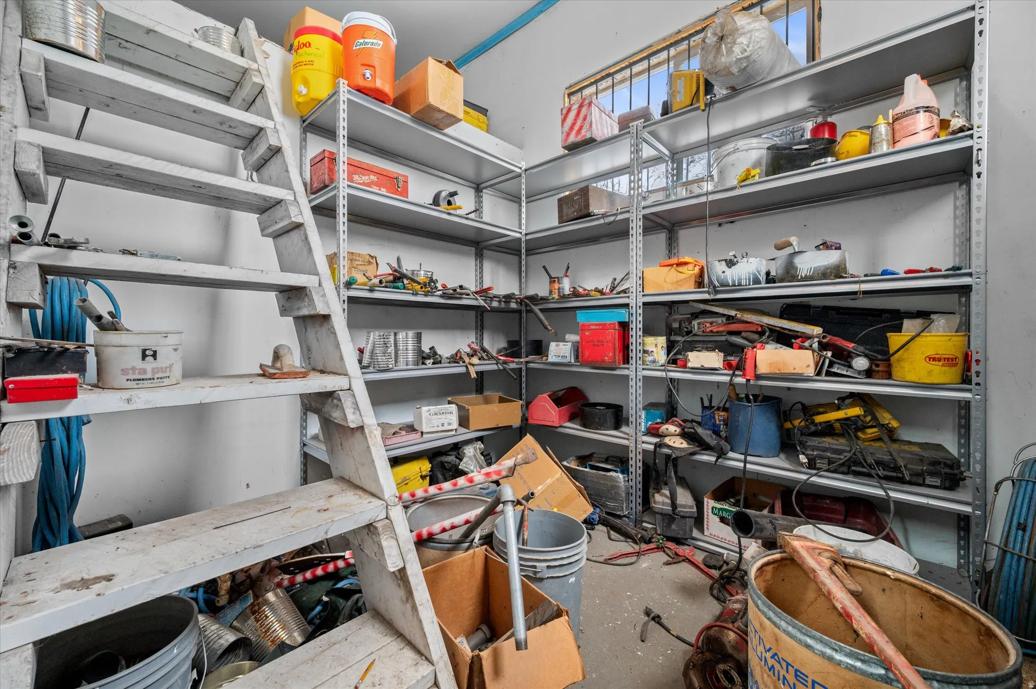 View of  enclosed rear storage room with stairs leading to up loft storage area