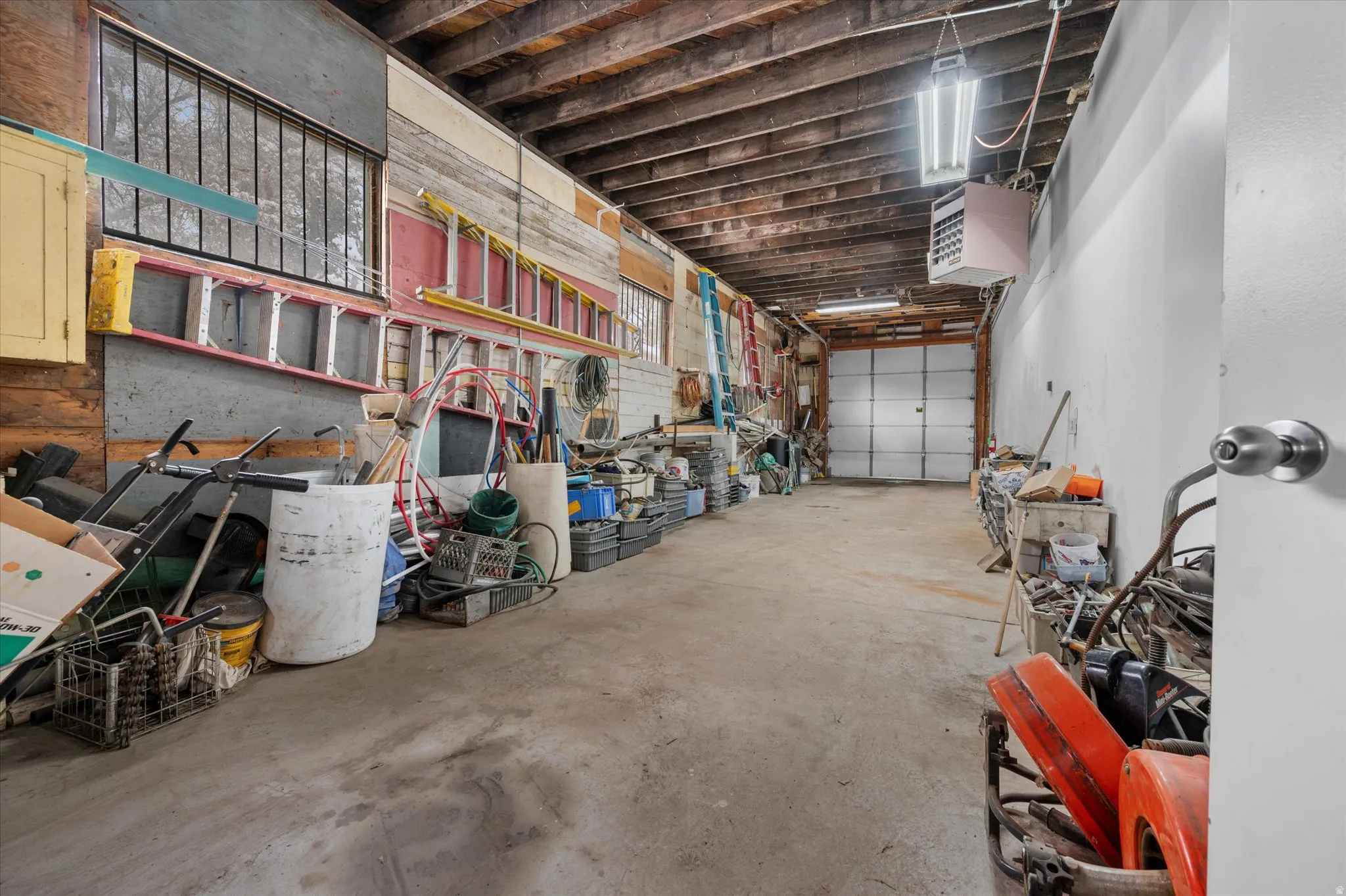 Extra length and height garage featuring a window, garage door opener, heating unit