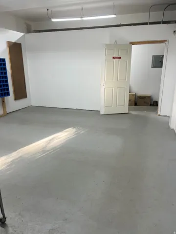 Polished concrete flooring, white painted walls, and overhead fluorescent lighting