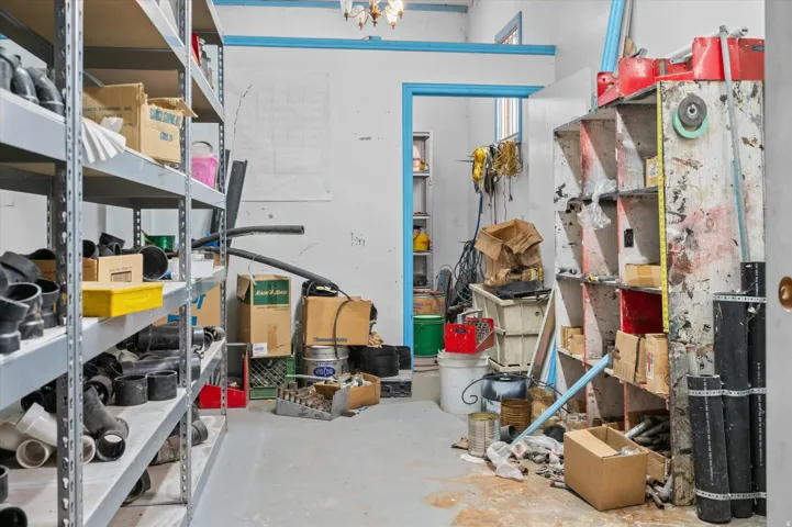 View of supply room/ storage area with bins and garage access