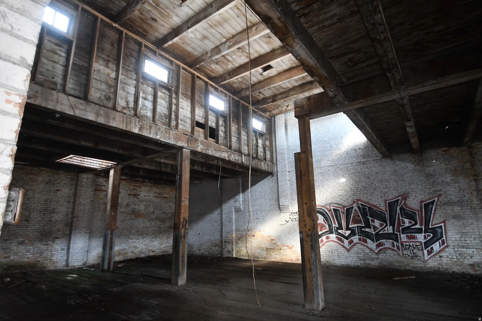 Misc room featuring brick wall and a high wooden ceiling