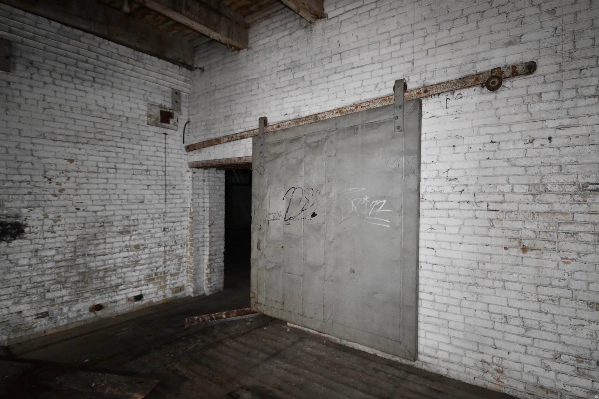 Miscellaneous room with brick wall, a high ceiling, and a barn door