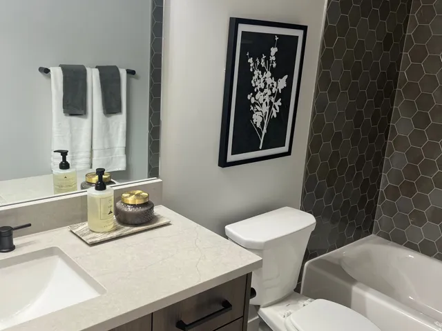 Bathroom featuring light tile patterned floors, vanity, and washtub / shower combination