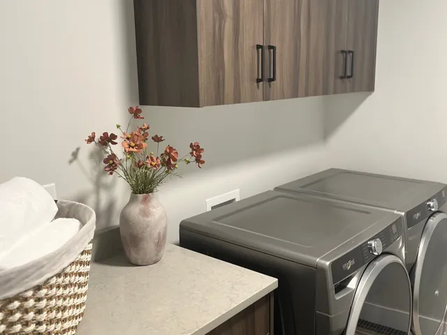 Laundry room with washing machine and clothes dryer and cabinet space