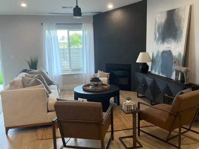 Living area with light wood-style flooring, a large fireplace, and recessed lighting