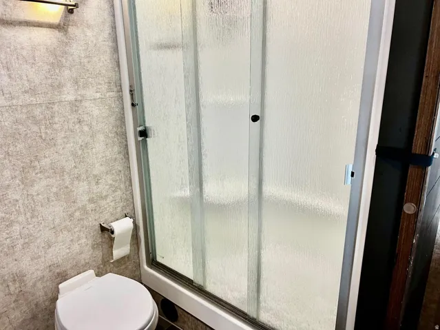 Bathroom with a stall shower and toilet