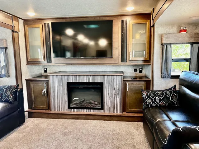 Carpeted living room with a fireplace and a textured ceiling