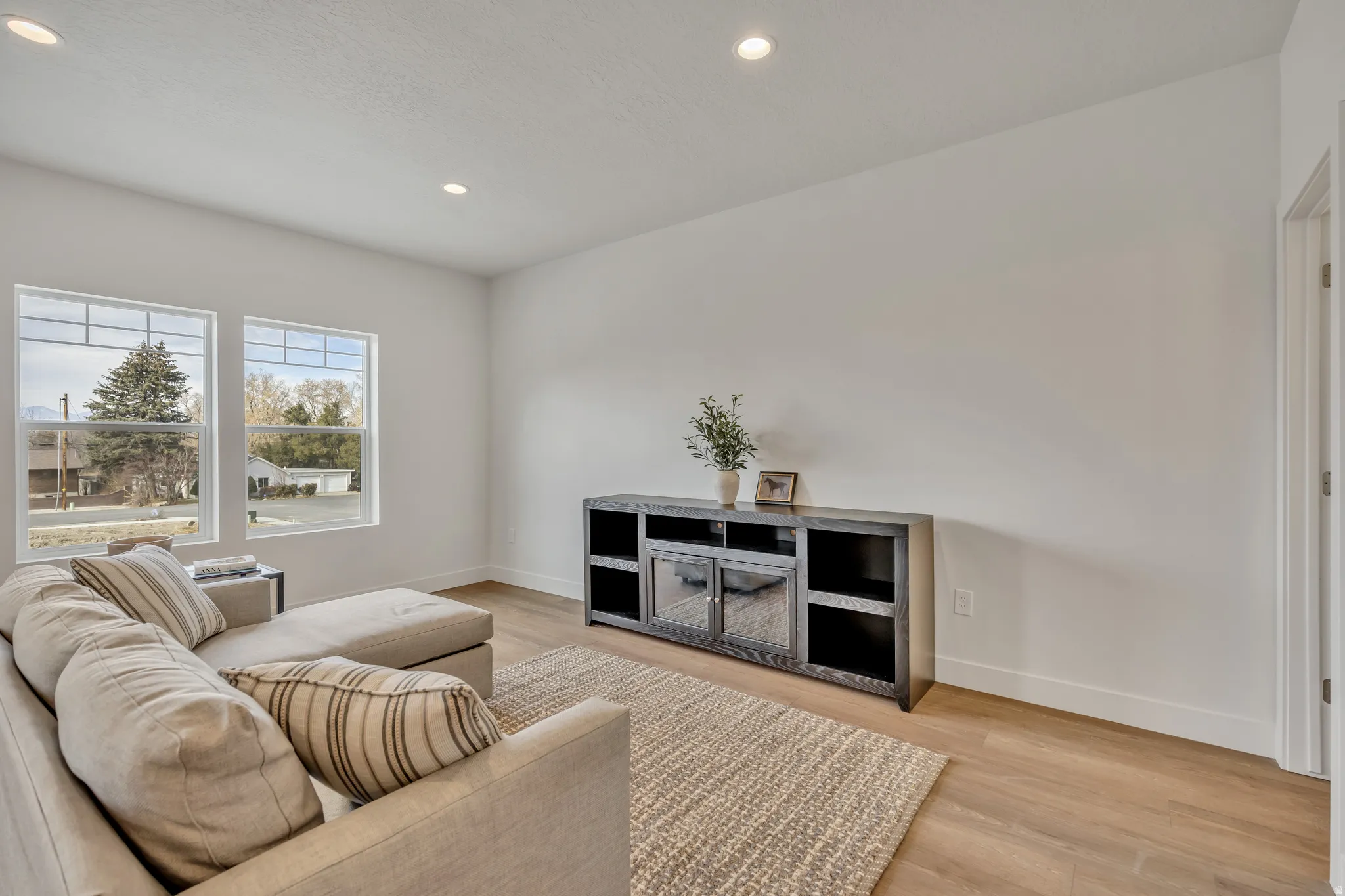Living area with light wood-style floors and recessed lighting