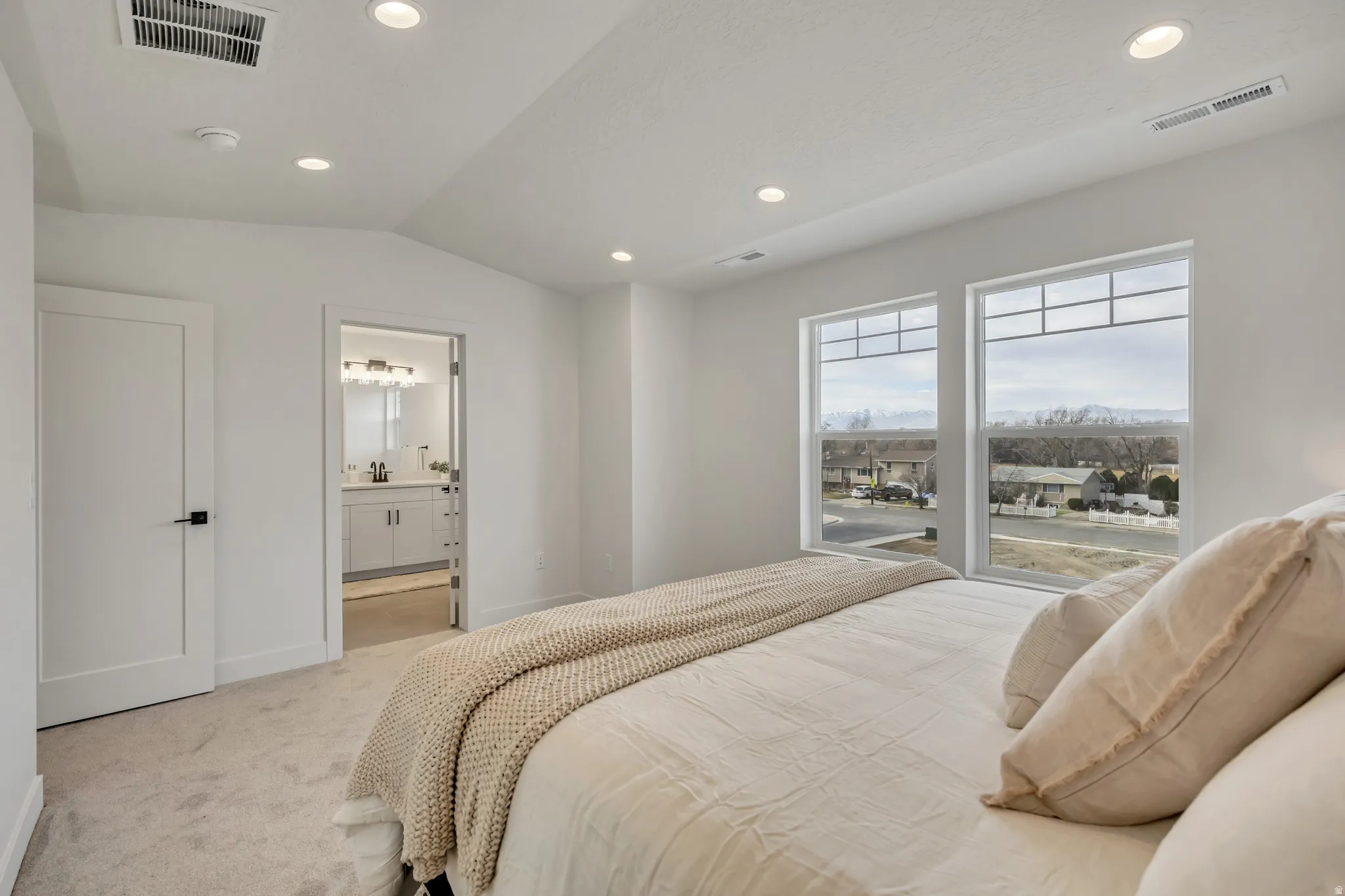 Bedroom featuring carpet flooring, vaulted ceiling, recessed lighting, and ensuite bath