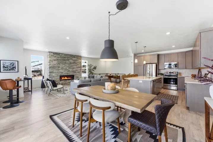 Dining space with light wood-type flooring, a stone fireplace, and recessed lighting