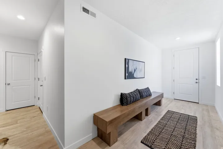 Foyer entrance with light wood-style floors and recessed lighting