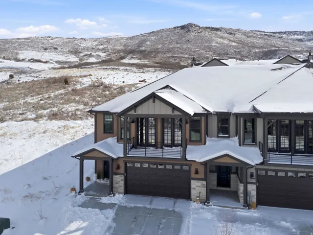 View of front of property with a garage, stone siding, a mountain view, and board and batten siding