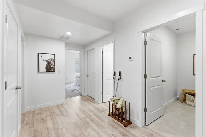 Hall with light wood finished floors and recessed lighting