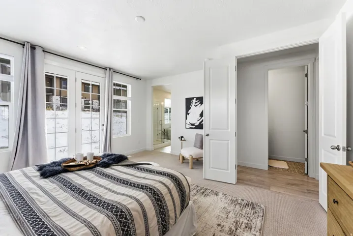 Bedroom with light colored carpet, access to exterior, and connected bathroom