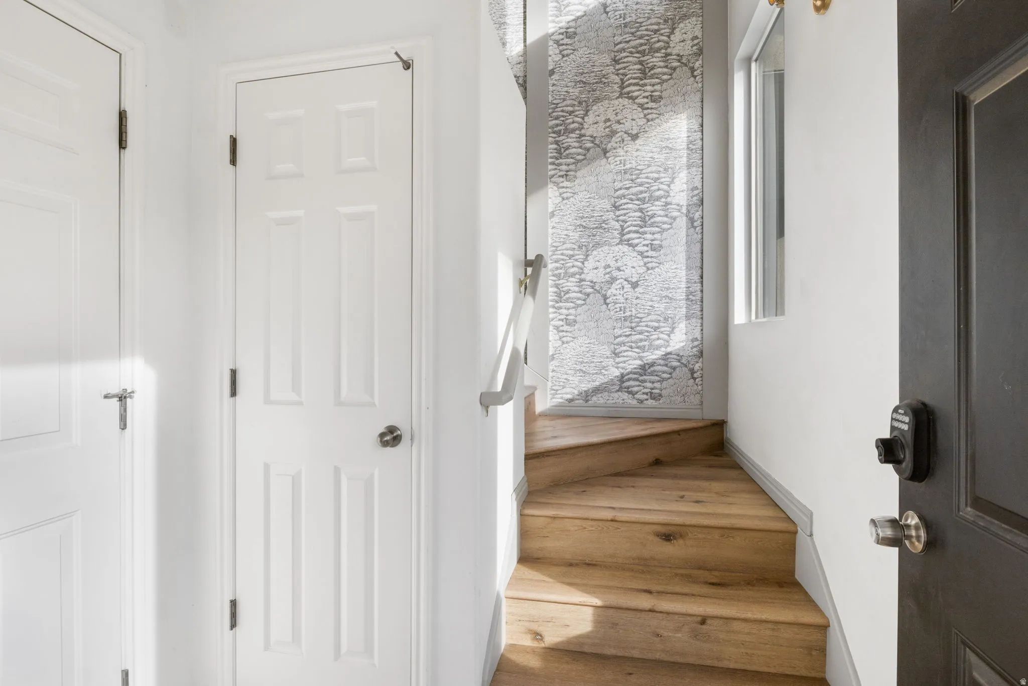Stairs with wood finished floors and baseboards