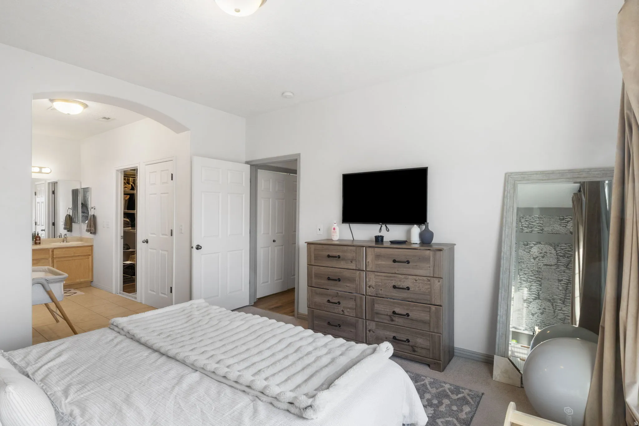 Master Bedroom with arched walkways, ensuite bathroom, and a walk in closet