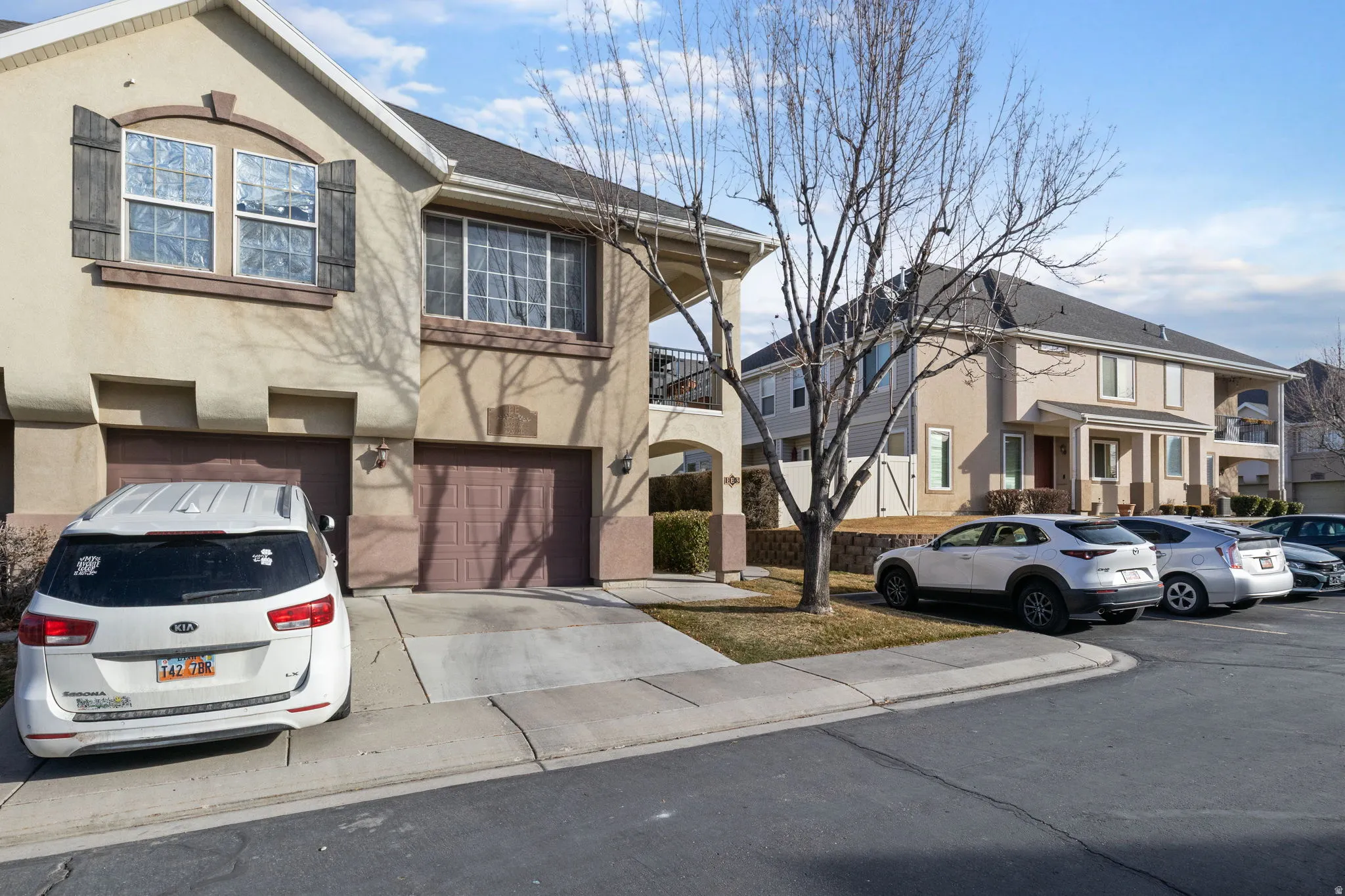 View of front facade with stucco siding, a garage, and driveway