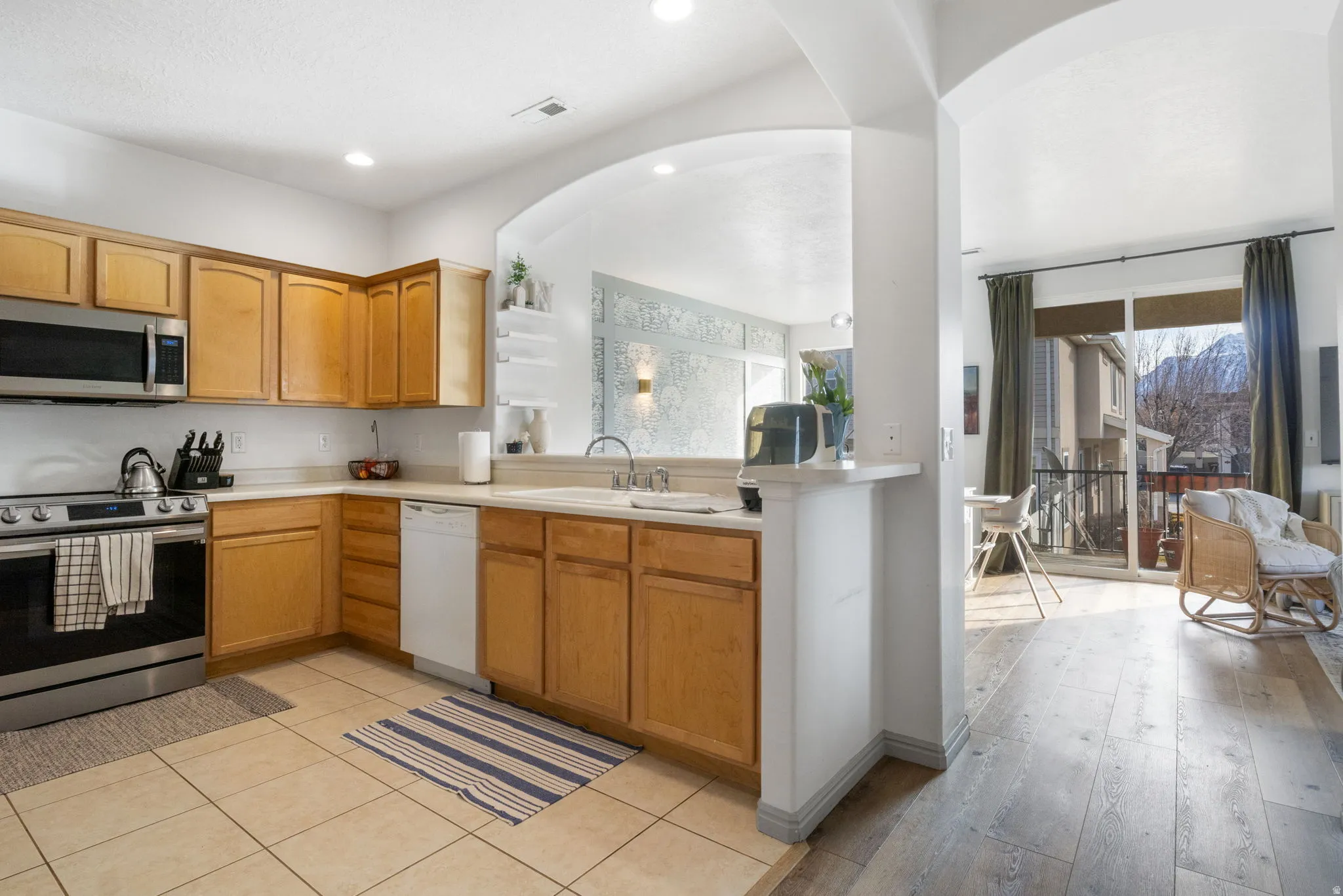 Kitchen with stainless steel appliances, light countertops, open floor plan, healthy amount of natural light, and recessed lighting
