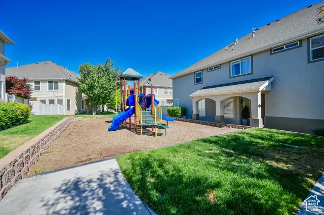 Community playground with a yard, a residential view, and a patio