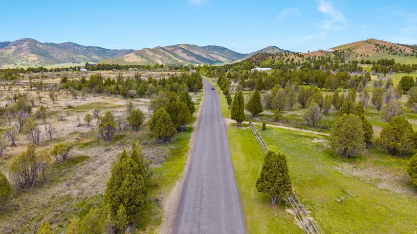 Paved road traversing expansive rural landscape with varied terrain