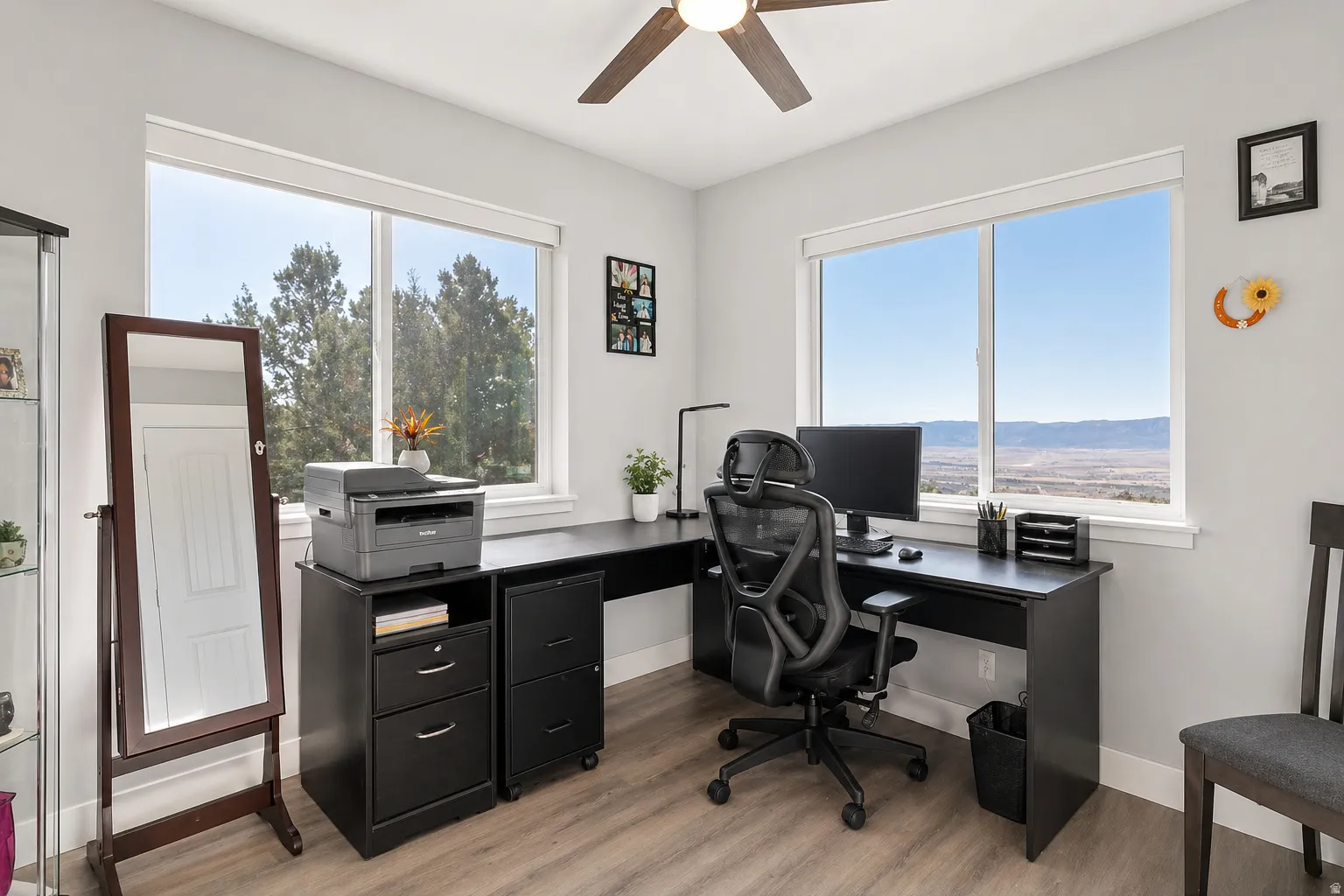 Home office with light wood-type flooring, ceiling fan, and healthy amount of natural light